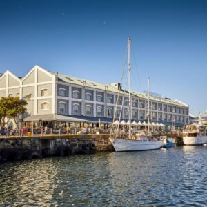 A large building with boats docked in a harbor at Victoria & Alfred Hotel by NEWMARK in Cape Town