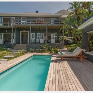 A house with a swimming pool in front of a house at Villa Blu Guesthouse in Hermanus