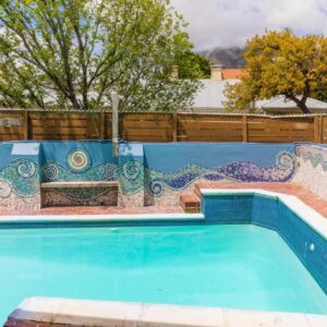 A swimming pool with a mosaic tile on the wall at Villa Viva Cape Town in Cape Town