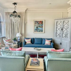 A living room with a blue couch and chairs at Whalehaven in Kalk Bay