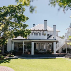 An exterior view of a white house with a yard at Whispering Oaks Guest House in George