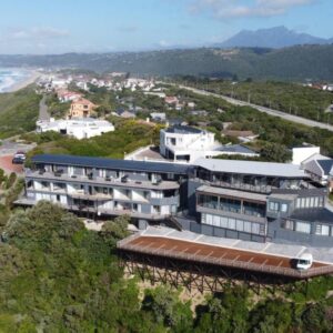 An aerial view of a building on a hill next to the ocean at Wilderness Beach Views in Wilderness