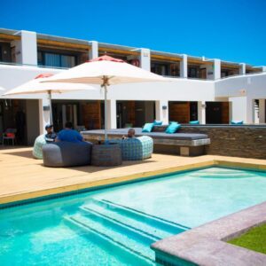 A villa with a swimming pool and a house at Windtown Lagoon Hotel in Langebaan