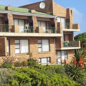An apartment building with balconies and trees at Wondersig Seafront Apartments in Lambertʼs Bay