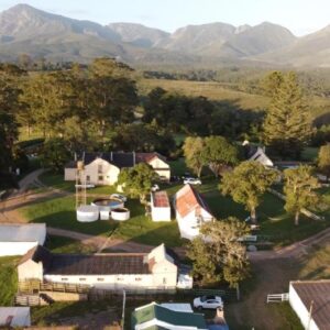 An aerial view of a farm with mountains in the background at Woodifields Farm Stay in George