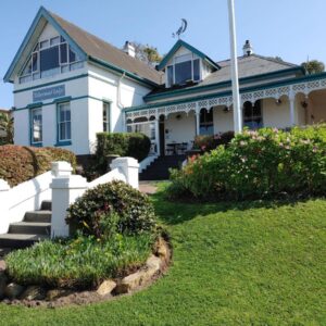 A blue and white house with a yard at Yellowwood Lodge in Knysna