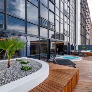 An apartment patio with a wooden deck and a pool at Zeeland Pier Aparthotel by Totalstay in Cape Town