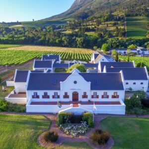 An aerial view of a large white house in a vineyard at Zorgvliet Wines Country Lodge in Stellenbosch
