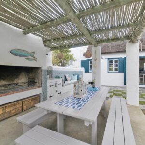 A patio with a table and a fireplace at Zuidste Huisie Fisherman's Cottage in Struisbaai