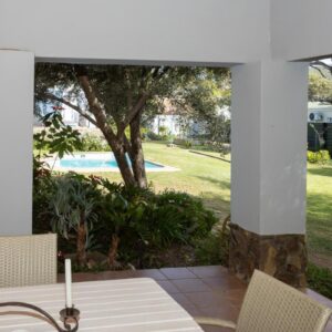 06 On Burger: a patio with a table and chairs and a pool