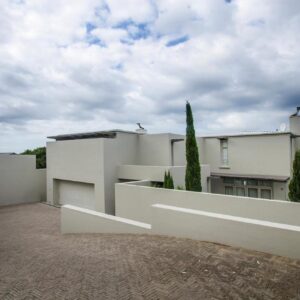 10 Elf Beach House: a white house with a white wall and trees