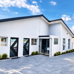 17 Rose Guesthouse: a white house with a car parked in the driveway