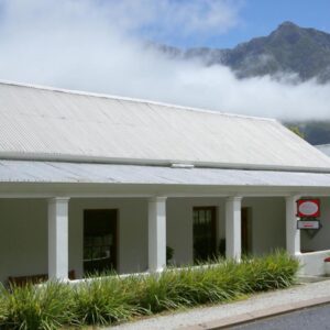33 Berg Selfcatering: a building with a grey roof with mountains in the background