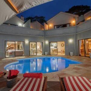 47th on Howard: a large swimming pool with two chairs and a house
