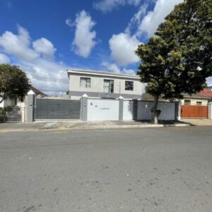 Adiel Guesthouse: a white house with a fence and a tree