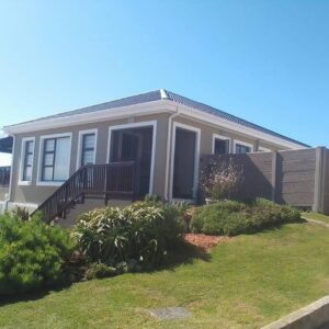 Afterglow Guesthouse: a small house with a fence and a yard