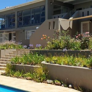 Agape Apartments: a house with a garden and a swimming pool