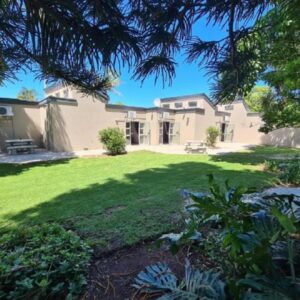 Alankri Guest Rooms: a large house with a yard in front of it