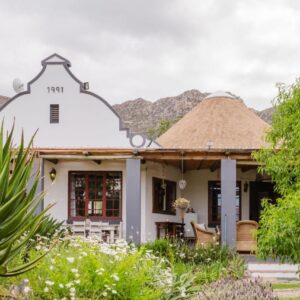 Anchorage Inn: a white house with a thatch roof