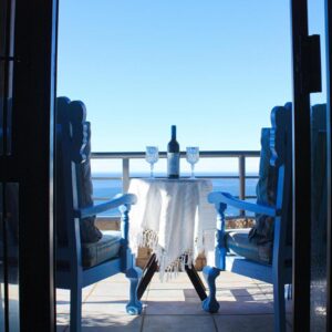Anni's Guesthouse: a table and chairs on a balcony with a view of the ocean