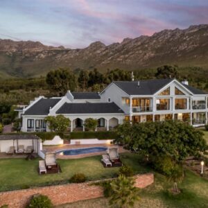 Apricot Gardens Guesthouse: an aerial view of a house with a pool and mountains
