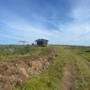 Askop Tented Escape & Adventure: a dirt road leading to a house in a field