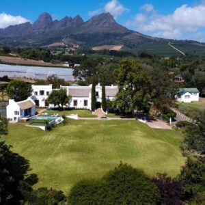 Avontuur Manor House and Wine Estate: an aerial view of a house with mountains in the background