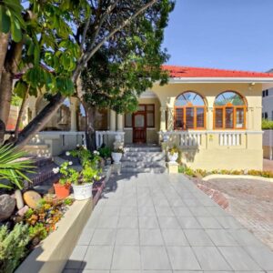 Bantry Breeze: a small yellow house with trees and plants