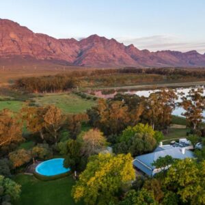 Bartholomeus Klip Farmhouse at Elandsberg Nature Reserve: an aerial view of a resort with a lake and mountains