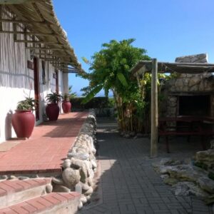 Baviana Beach Lodge - Jacobsbaai - Jacobs Bay: a walkway next to a building with a fireplace