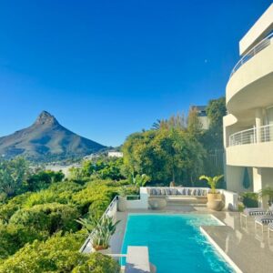 Bay Reflections Camps Bay Luxury Serviced Apartments: a house with a swimming pool with a mountain in the background