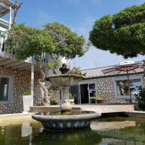 Beachcombers: a large fountain in front of a house