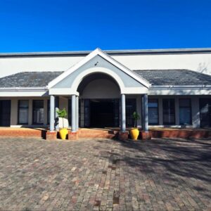Beds Inn George: a white house with two potted plants in front of it