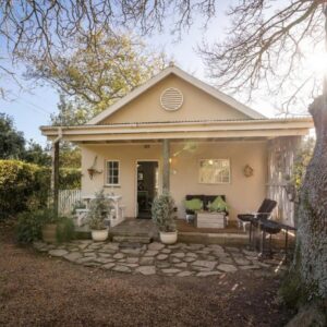 Belfield Wines and Farm Cottages: a small white house with a bench in front of it