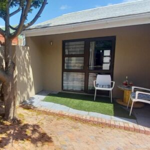 Bellville Self Catering: a house with two chairs and a table and a window