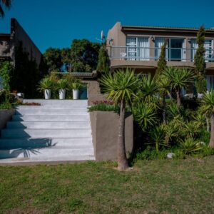 Benguela: a house with stairs and palm trees in front of it