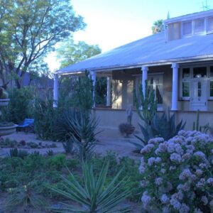Bisibee Guest House: a garden in front of a house with a fountain