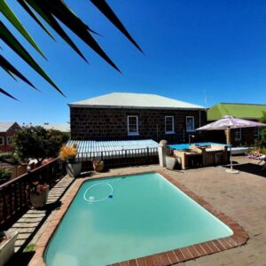 Blue Whale Lodge: a swimming pool in a yard with a house