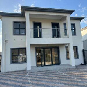 Bokwe's Guest House- Cape Town: a white house with black windows and a fence