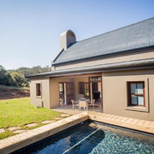 Botlierskop Bush Villas: a house with a swimming pool in front of it