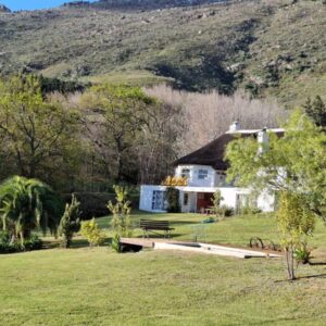 Brambleberry Farm: a house in the middle of a field with a hill