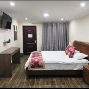 Cape Hope Inn: a bedroom with a bed and a television and a table