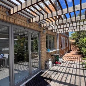 Cape One Guest House: a pergola on a house with a patio