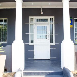 Cape Town Micro Apartments: a house with a white door and two potted plants