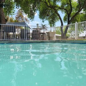 Cape Winelands Business Villas: a swimming pool with blue water in front of a white fence