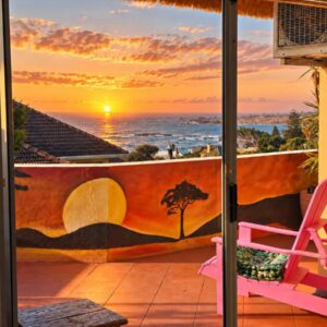 CapeAura Camps Bay: a pink chair on a balcony with a view of the ocean