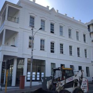 CapePod Sea Point: a white building with a tractor parked in front of it