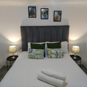 Cethone Luxury Guest House: a bedroom with a large white bed with two lamps