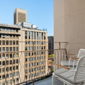 Charlie and the Chairman Modern Apartments: a balcony with two chairs and a view of a building