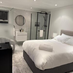 Cherrywood Guest House: a bedroom with a large white bed and a mirror